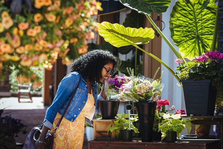 Resident smelling flowers within Seton community in Calgary, Alberta